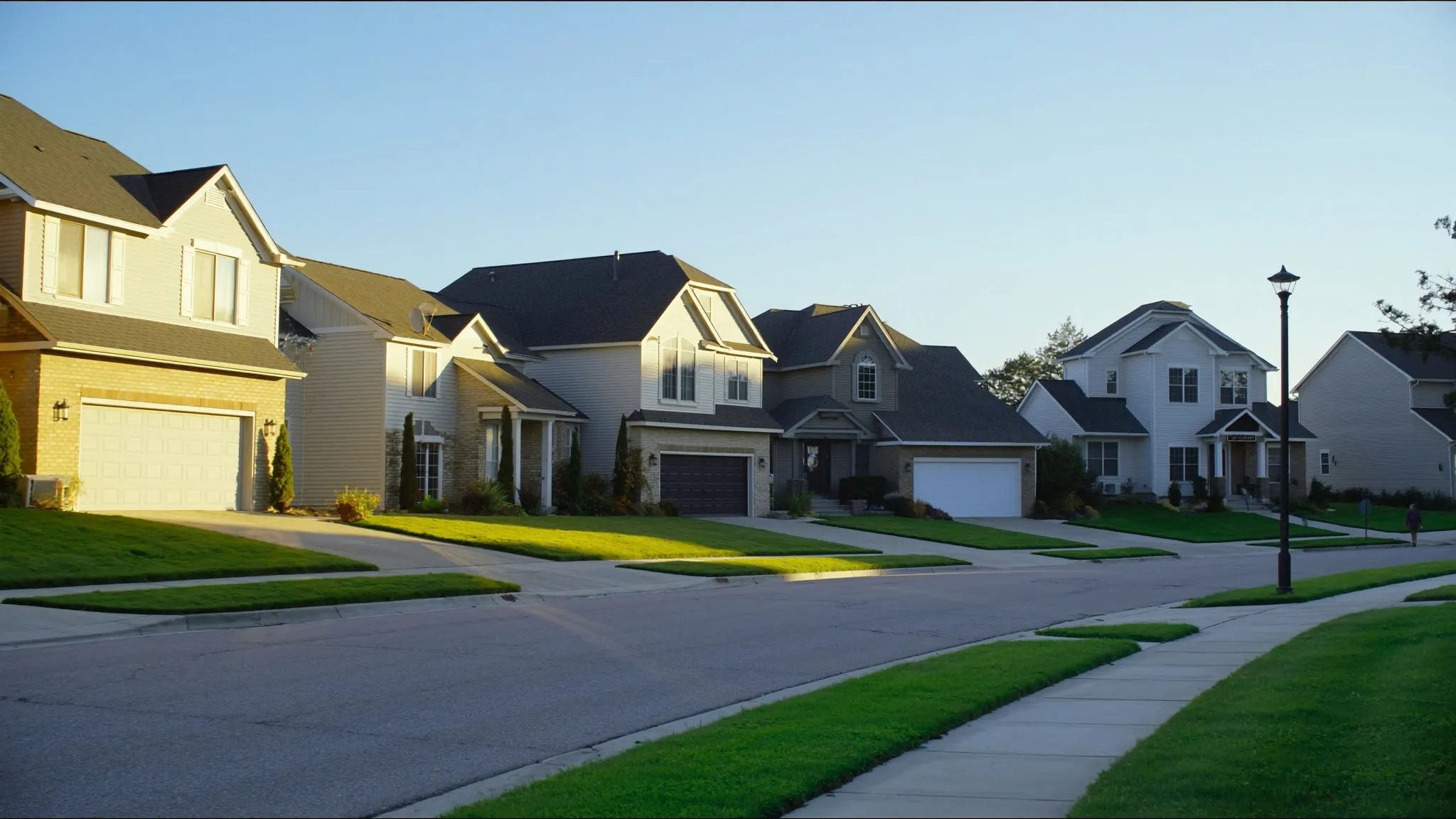 Suburban neighborhood street of single-family homes at golden hour